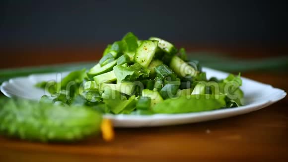 新鲜的黄瓜和蔬菜沙拉在木制盘子里视频的预览图