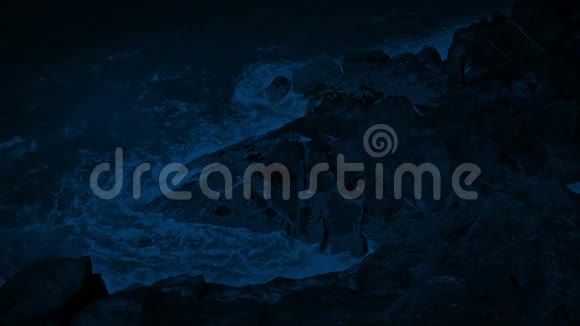 夜间在大石头上的波浪破碎视频的预览图