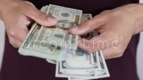 一个人漫不经心地把一包美元记在手里美元视频的预览图