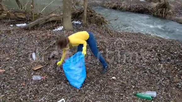 女志愿者清理河边的垃圾在户外捡垃圾生态和环境概念视频的预览图