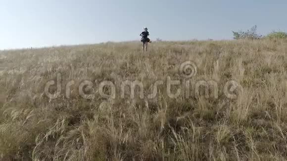 一个背着背包的女孩从一个陡峭的斜坡上逃跑了慢动作视频的预览图