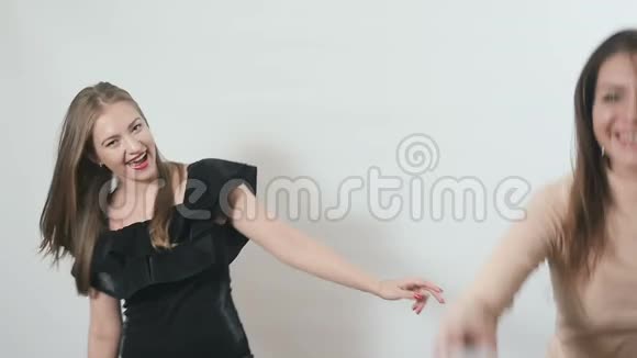 两个年轻女孩在白色背景下慢动作跳舞视频的预览图