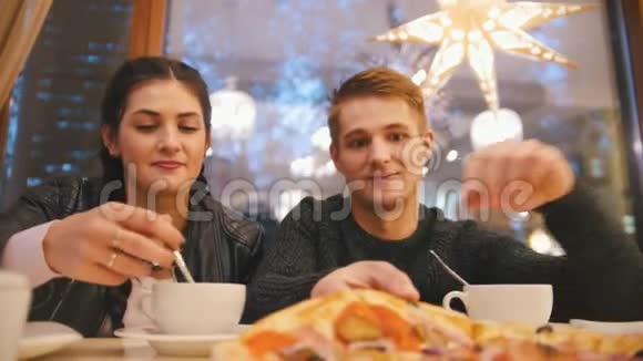 男孩和女孩在咖啡馆喝茶吃披萨视频的预览图
