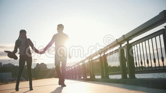 幸福的爱人男孩和女孩在日落时分沿着长廊散步视频的预览图