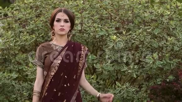 公园里穿着豪华纱丽礼服的印度模特视频的预览图