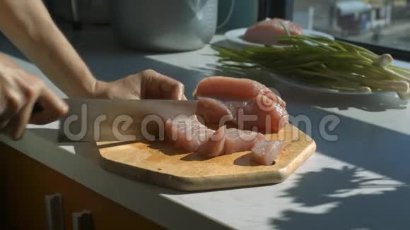 家庭主妇双手将肉切成长方体放在木桌上视频的预览图