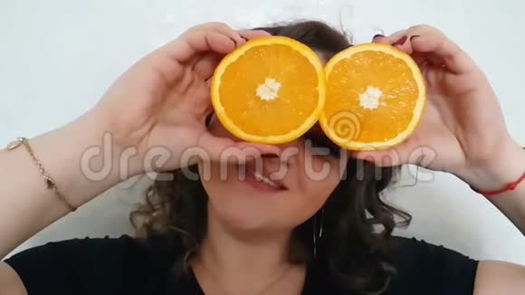 丰满的女孩一个橘子紧紧抓住眼睛快乐的切片视频的预览图