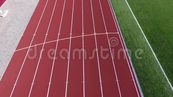 穿着运动服的运动员沿着足球场的跑道跑视频的预览图