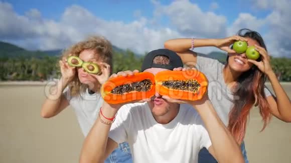 三个有趣的朋友愚弄周围与异国热带水果素食健康饮食泰国范甘高清慢速运动视频的预览图