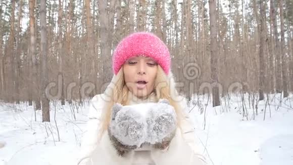 冬季娱乐理念冬天公园的年轻女子手里拿着雪视频的预览图