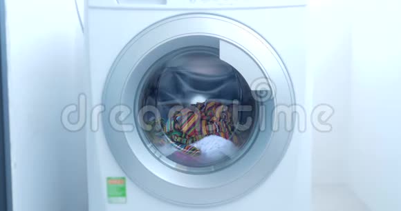 关闭工业洗衣机洗涤彩色服装和白色亚麻白色条纹服装气缸旋转视频的预览图