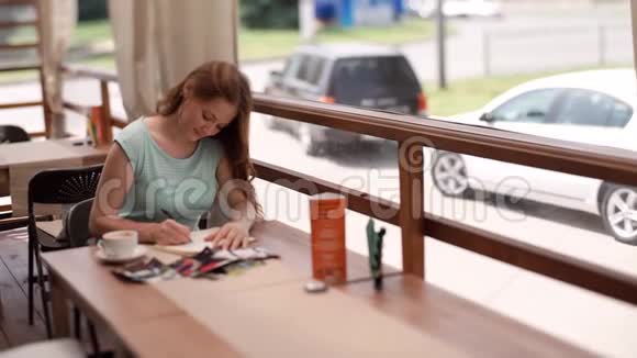 女商人坐在咖啡馆的桌子旁在笔记本上做笔记视频的预览图