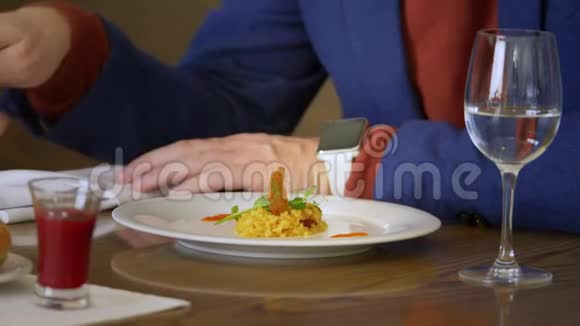 商务午餐期间年轻人在餐馆里用叉子和刀子吃饭视频的预览图