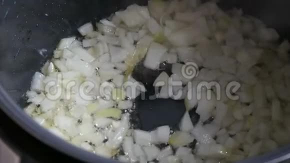 在热沸油中炒洋葱煎锅的特写烹饪蔬菜视频的预览图
