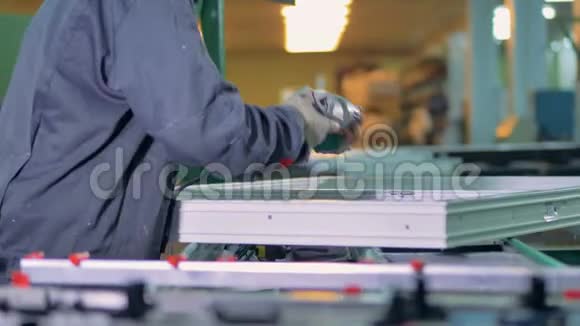 一个PVC窗口车间工人完成添加金属配件视频的预览图