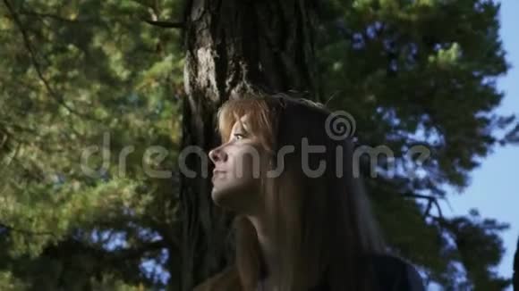 一个漂亮的女孩在森林里徘徊女孩迷路了背景中天空视频的预览图