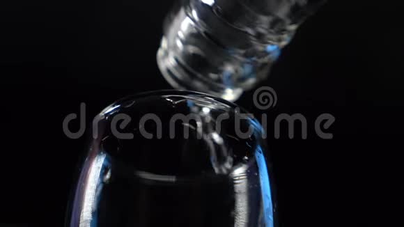特写镜头透明酒精饮料从瓶子里倒入玻璃杯视频的预览图