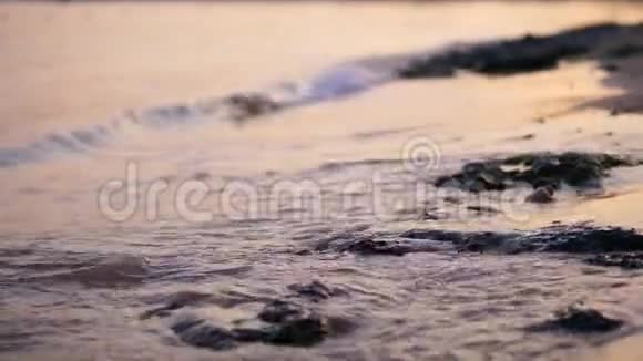 特写海浪潮水沙滩上的海浪在阳光下温暖的夏日日落视频的预览图