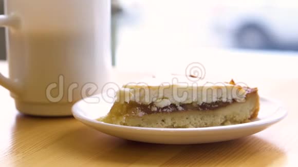 咖啡厅窗边的桌子上放着蛋糕和茶有选择的焦点木桌上的咖啡和覆盆子烤饼视频的预览图