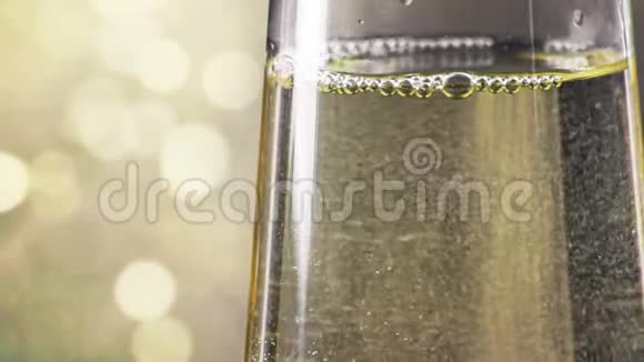 在金色bokeh背景下用金色气泡填充香槟长笛的特写镜头黄金奢华度假的概念快乐视频的预览图