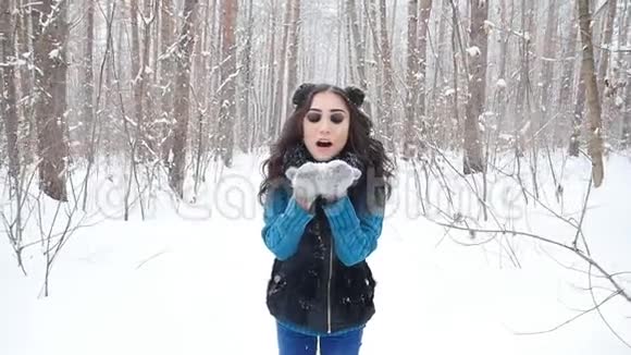 冬季娱乐理念冬天公园的年轻女子手里拿着雪视频的预览图