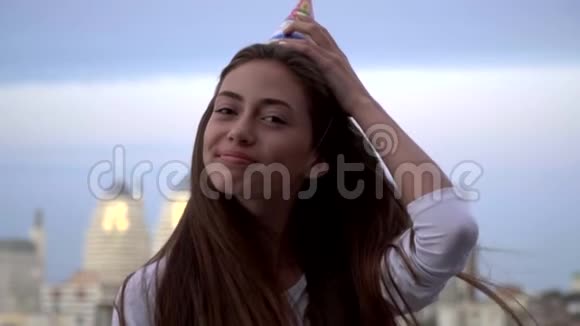 一个快乐的长发黑发女人在短上衣固定在她的头上微笑慢动作生日快乐视频的预览图