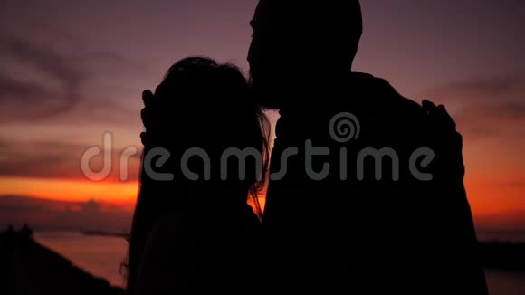 浪漫的年轻夫妇剪影拥抱和亲吻在惊人的日落高清慢速运动泰国范甘视频的预览图