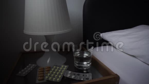 药物药物药片和一杯水放在床旁的桌子上视频的预览图