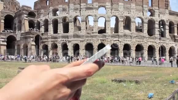 手持年轻的白种人女游客用手机在美丽的欧洲古城风景上发短信视频的预览图