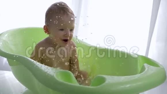 宝宝洗澡微笑的小男孩洗澡时玩水视频的预览图