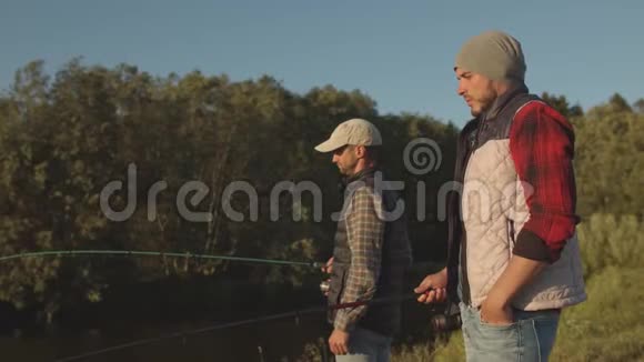渔民朋友用旋转棒在河上钓鱼一个周末的渔夫爱好休闲和活跃视频的预览图