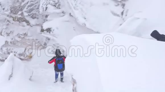 一群游客从白雪覆盖的山顶上下来视频的预览图