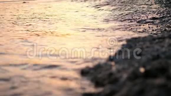 特写海浪潮水沙滩上的海浪在阳光下温暖的夏日日落视频的预览图