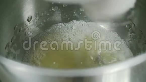 电动搅拌器在室内厨房混合鸡蛋混合物视频的预览图