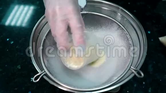 女厨师将面粉倒入室内餐厅厨房的筛子中视频的预览图