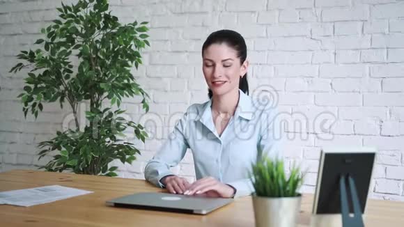 年轻的商务女性在办公桌后微笑视频的预览图
