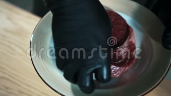 手套里的特写手拿着一块生肉放在桌子上视频的预览图
