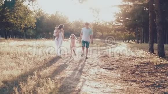 幸福的年轻家庭在外面度过绿色的时光视频的预览图