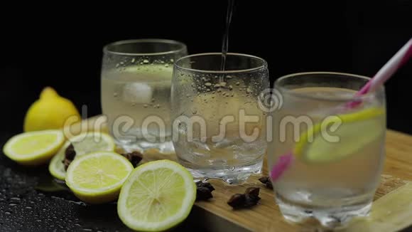 将柠檬汁倒入冰块和柠檬片的玻璃杯中柠檬酒精鸡尾酒视频的预览图