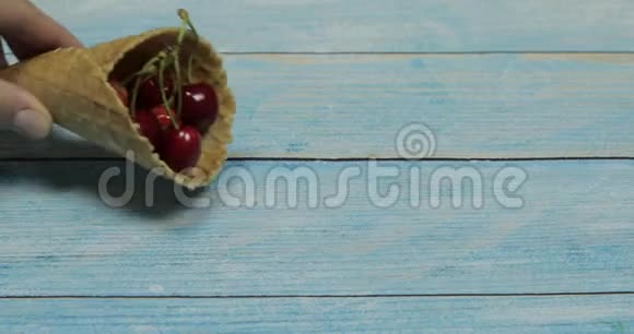 浆果冰淇淋蓝色木制背景的华夫饼中的樱桃浆果视频的预览图