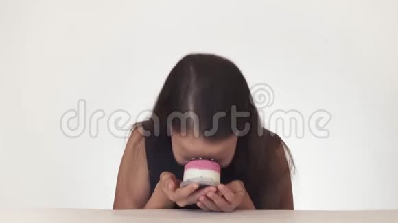 美丽淘气的少女快乐地在白色背景的股票视频上涂抹蛋糕的脸视频的预览图