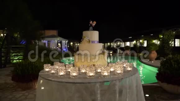 泳池背景下的大型婚礼蛋糕滑块夜晚视频的预览图