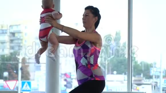 一个女人把一个孩子抱在怀里蹲着为母亲训练视频的预览图