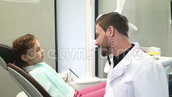 可爱的牙医和他年轻的病人谈话视频的预览图
