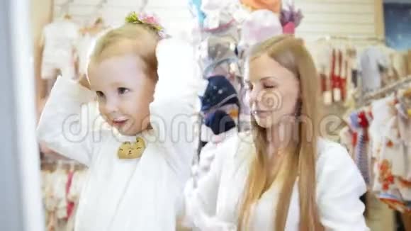 儿童的服装店一个金发小女孩在买漂亮的帽子视频的预览图