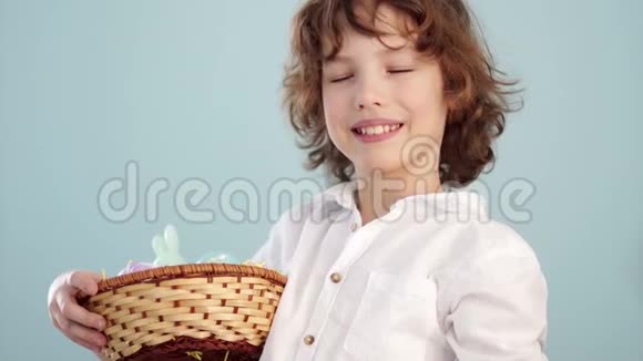 有复活节篮子的男孩少年伸出的手上放着一个蓝色的复活节彩蛋视频的预览图