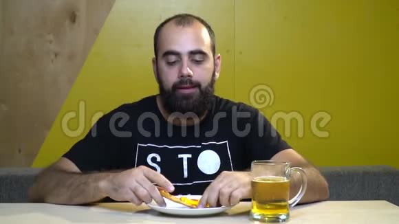 一个叫胡子的人在咖啡馆里吃披萨胃口很大把整件都吃到底他喜欢吃东西他吃饱了视频的预览图
