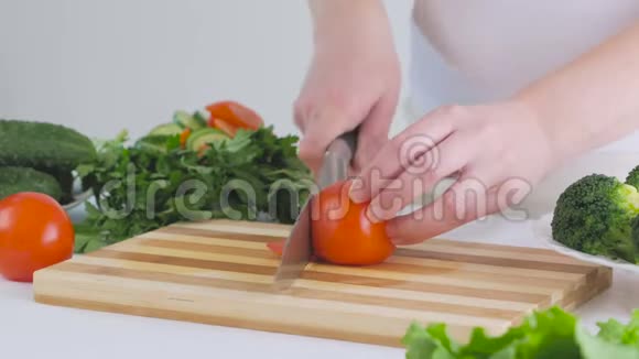 一个女人在厨房里切一个西红柿准备一份美味的新鲜蔬菜沙拉作为午餐视频的预览图