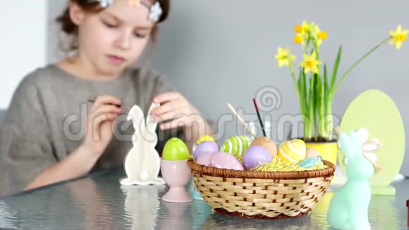 复活节快乐一个可爱的卷发女孩正准备庆祝复活节她画了一只兔子的木制身材视频的预览图
