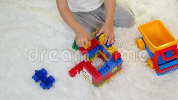 快乐的孩子在彩色积木里玩在白色背景上坐在地板上子在一个视频的预览图